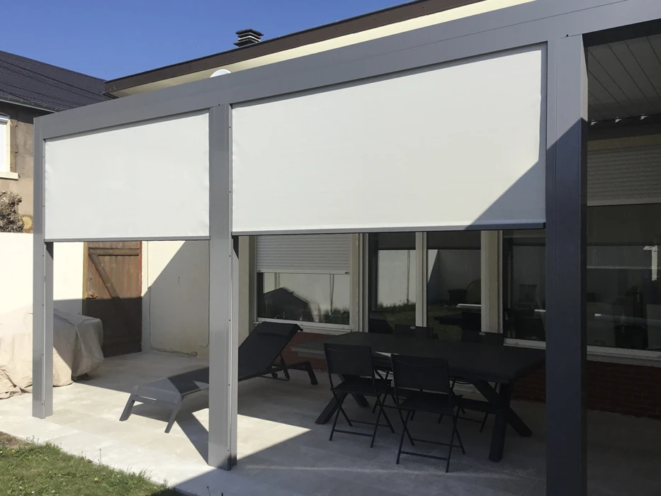 Terrasse extérieure résidentielle équipée d'une pergola moderne avec store banne déployé offrant de l'ombre