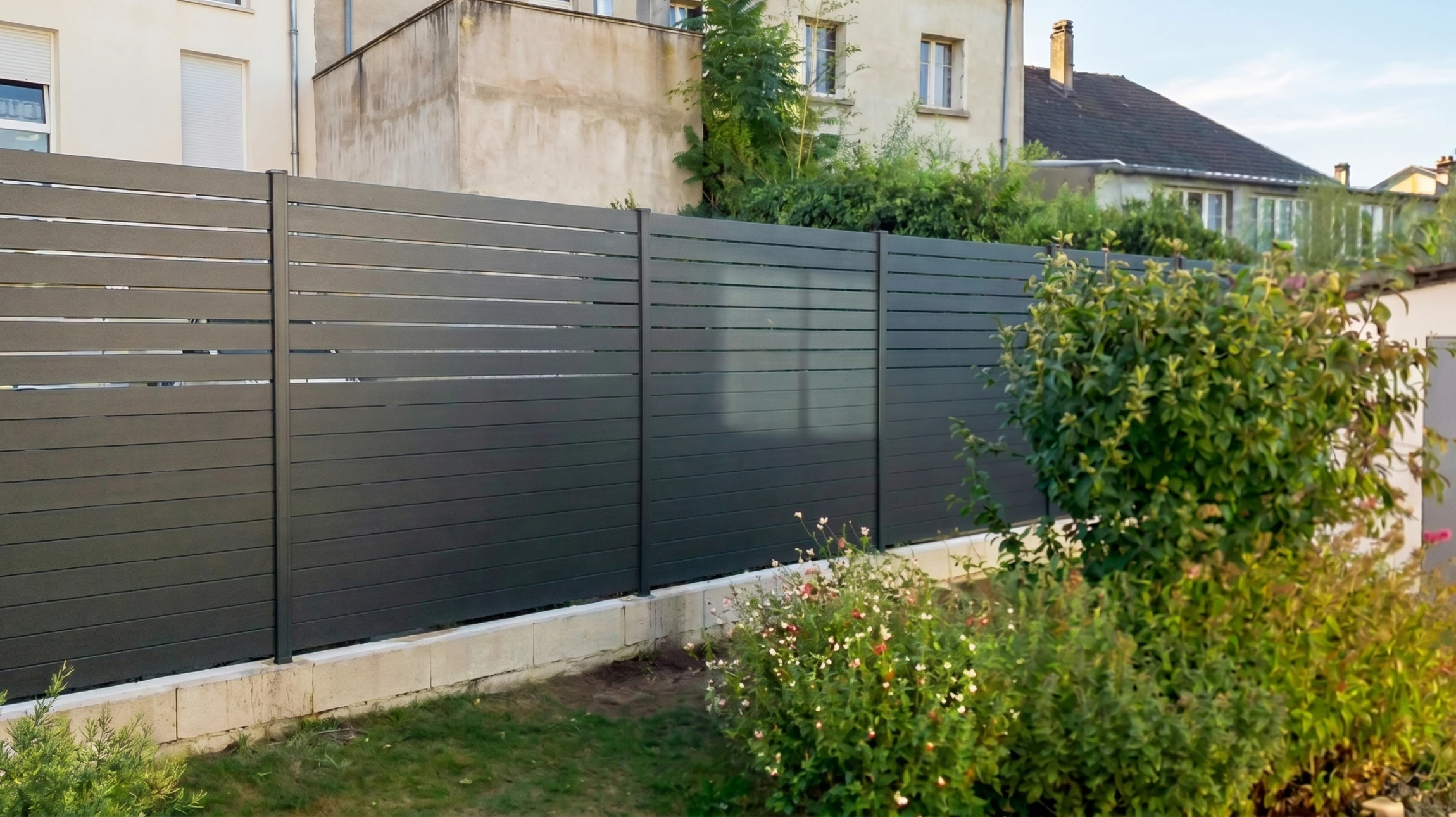 Clôture résidentielle extérieure avec palissade blanche en PVC ou bois peint, montée sur muret en béton avec chaperon brique